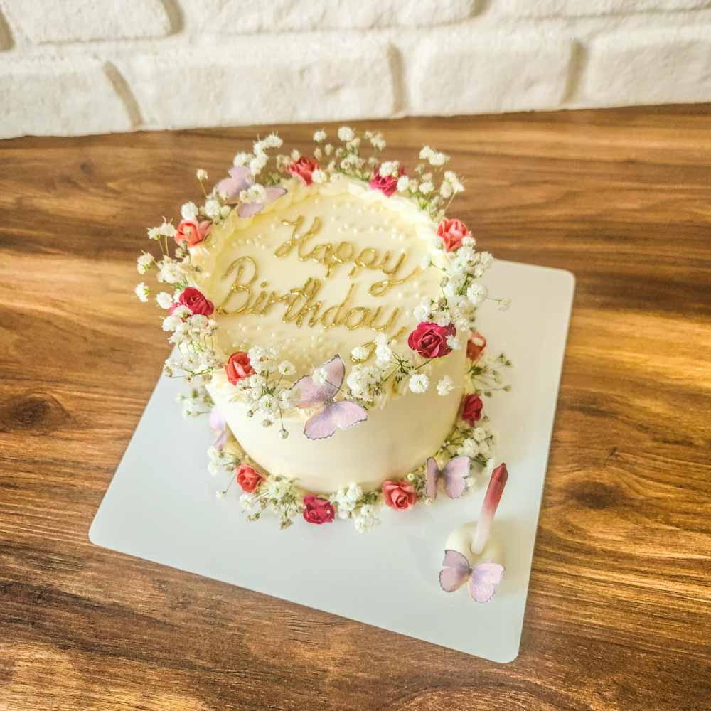 Çiçek ve cipsolar ile süslenip tasarlanmış muhteşem görüntüsü ve sim detayları ile parıldayan premium yazılı pasta