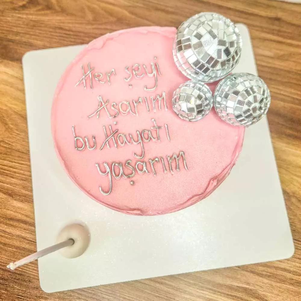 Yazılı Pasta ve disko topu figürüyle süslenmiş, kutlamalara enerji katan butik pasta modeli.